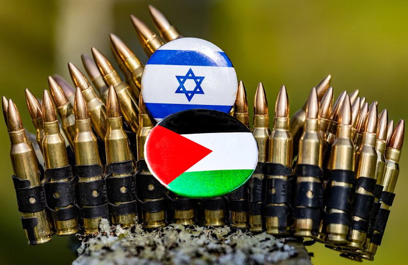 Военный конфликт Ирана и США: под угрозой газовые проекты Китая и будущее Центральной Азии Патронная лента с бронебойными пулями, поверх которой лежат значки с флагами Израиля и Палестины — символ вооружённого противостояния Ирана и Израиля