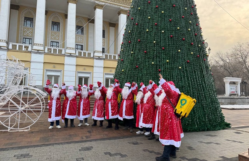 Курьеры Glovo в костюмах Санты подарили новогоднее настроение прохожим на Арбате в Алматы Курьеры Glovo в образах Санты поздравили жителей Алматы